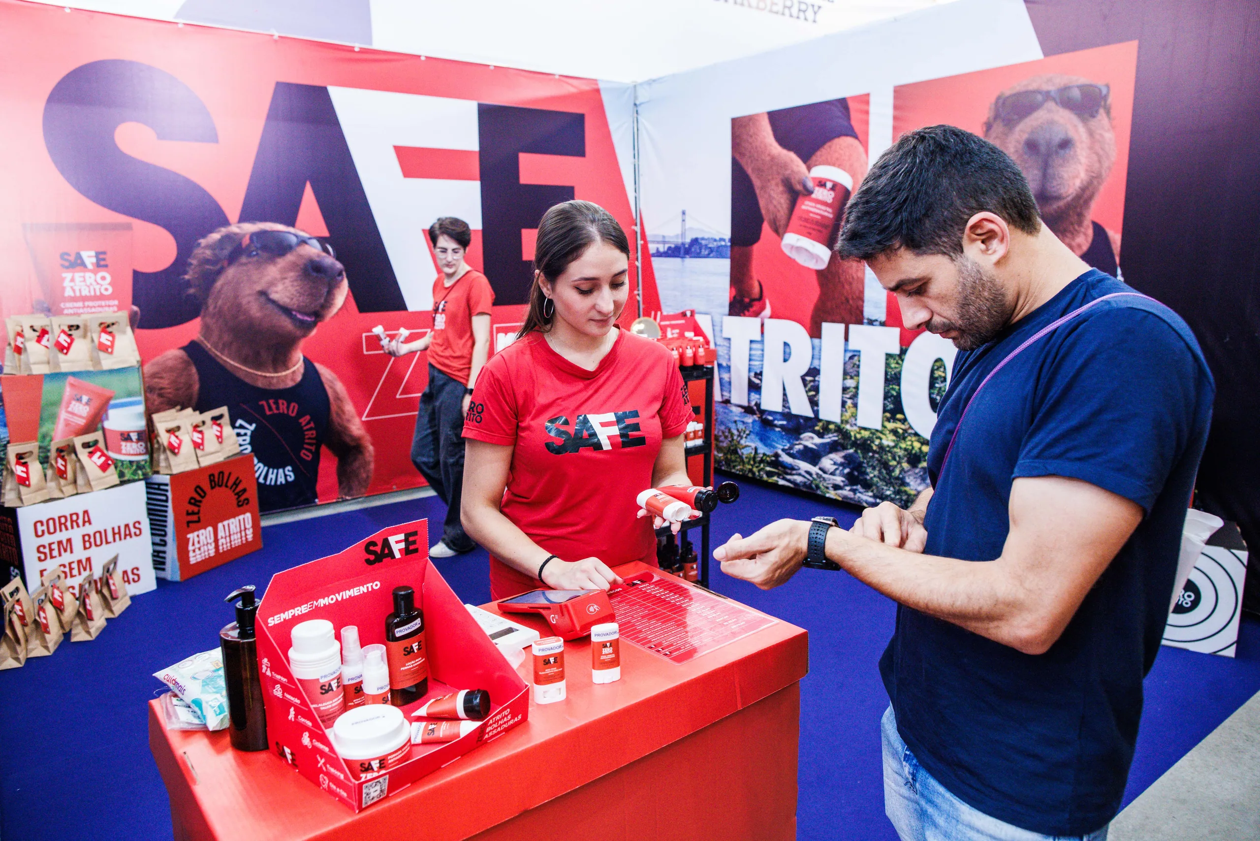 Estande de produtos para corredores na Oakvillage: expositora atende um visitante