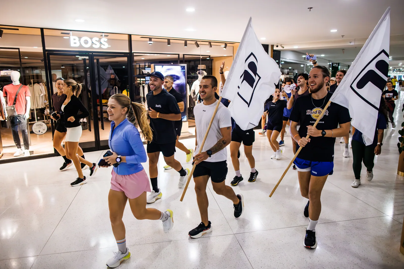 Corredores com bandeiras FILA atravessam o Villa Romana Shopping no treinão